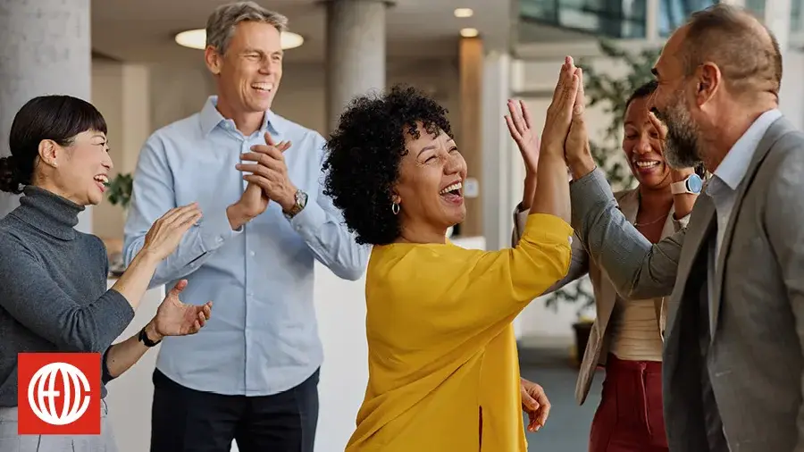 Team celebrating with a high five in the office
